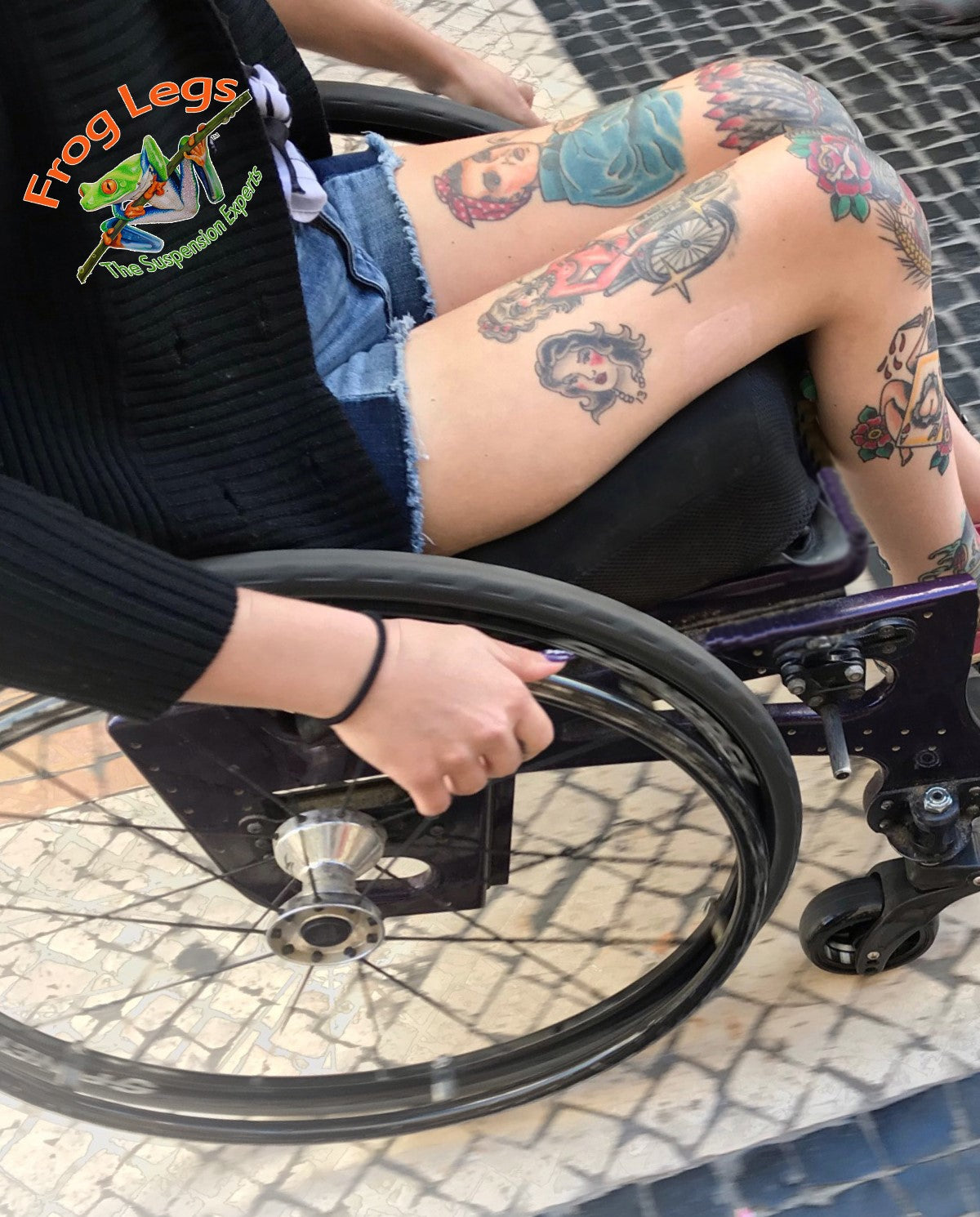 Women with tattoos riding in her wheelchair with Frog Legs suspension forks